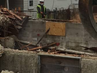 A hand-painted word, "Peace" inside the basement at 308  Main Ave. as Pasquazzi Bros. demolishes the home Tuesday morning. 