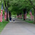 A man an boy walk along a flag-lined road inside Pawtuxet Memorial Park on Memorial Day, 2015.