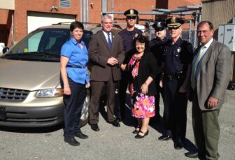 From left, Major Christine Kelley, Mayor Scott Avedisian, Lt. Michael Gilbert, Council President Donna Travis,  Al Melucci, Chief Col. Stephen McCartney, and Dep. Chief Michael Babula, with a van donated to the Warwick Police Explorers by the Travis family. 