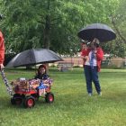 CREDIT: Rob Borkowski] Jacob Burrows tows his niece, Mary Burrows, around the Warwick Veterans Memorial on West Shore Road on Memorial Day in 2016. Following them is Mary's grandmother, Debra Burrows.