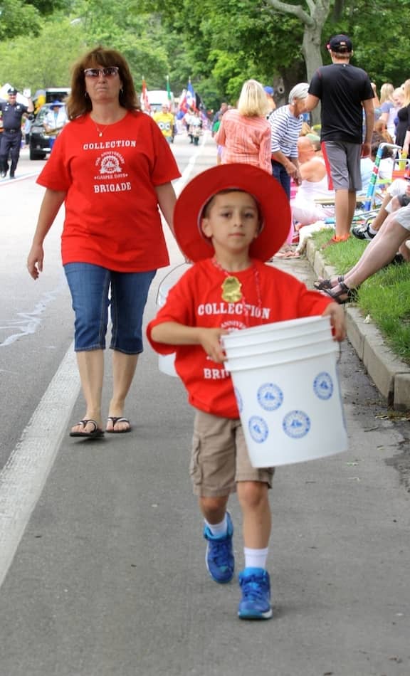 [CREDIT: Beth Hurd] Members of the "collection brigade" collect donations along the parade route to help offset the costs of this year's parade.