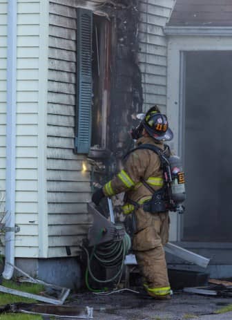 [Brian Calci] A Warwick Firefighter inspects the damage done by a fire at 57 Puritan Drive Wednesday evening.