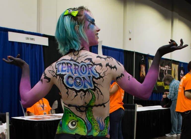 [CREDIT: Mary Carlos} An airbrushed member of the Providence Roller Derby shows off her temporary art during the 2014 Terror Con.