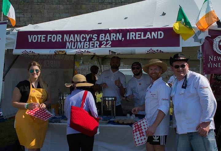 [CREDIT: Mary Carlos] Nancy’s Barn, hailing from Ballyliffin Ireland, serves up their chowder at the Great Chowder Cook-Off at Fort Adams, Newport. At far right, in straw hat, Gavin McNaulty, owner, charms the crowd. With him are Ronan Gildea, Bernard Harkin and Kieran Duey.