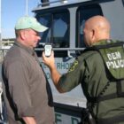 [CREDIT: DEM] Officer Hill uses a portable breath test instrument to measure a boater’s blood alcohol level.