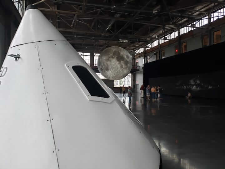 [CREDIT: Rob Borkowski] A Warwick-crafted replica of the Apollo 11 command module rests at the Waterfire Arts Center, not far from 7-meter replica of the moon, the capsule's destination. 