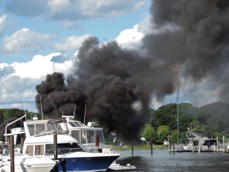 [CREDIT: Lincoln Smith] Black smoke from a boat fire Saturday at the Fair Winds Marina filled the sky with thick black smoke. 