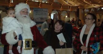 [CREDIT: Rob Borkowski] Santa was one of the many attractions at the RI Author Expo at Rhodes on the Pawtuxet Dec. 7, 2019. From left are Santa, played by Michael Silva, his daughter Riley Silva, 9, months, Rhoda Silva and Mary Ann Guerin.