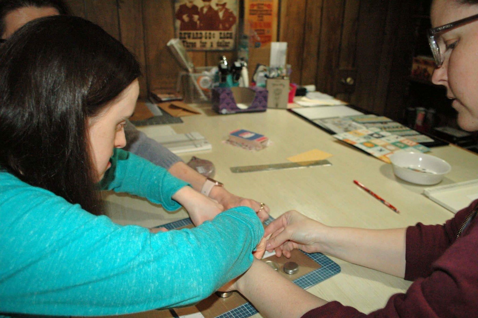 [CREDIT: Rob Borkowski] Katie Lowe works on a new Cheetah Greetings card with the help of Sarah Holt and her mom, Claudia.