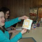 [CREDIT: Rob Borkowski] Katie Lowe, owner of Cheetah Greetings, shows off one of her hand-crafted greeting cards. She learned about marketing her business at a RIDDC workshop.