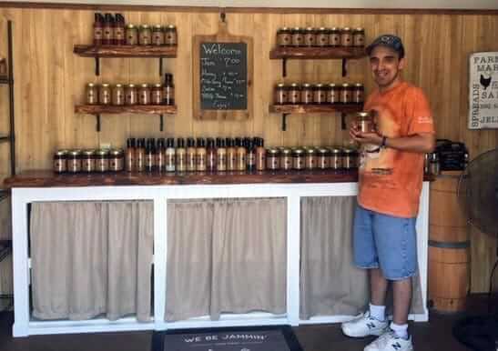 [CREDIT: Debbie Wood] Jason Wood, proprietor of We Be Jamming, at his shed/shop in Warwick on West Shore Road, with a wide selection of jams and spreads for sale.