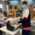 [CREDIT: Trudeau Center] Liam, a Pathways student, using one of the two laminating machines a Fogerty Foundation grant afforded the Trudeau Center.