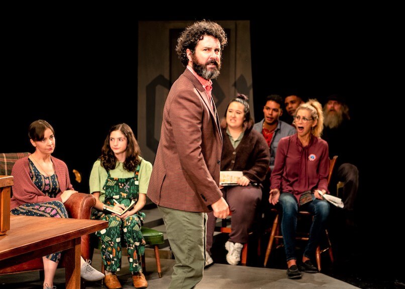 [CREDIT: Peter Goldberg] Sean McConaghy as Dr. Thomas Stockman in Gamm Theater's "A Lie Agreed Upon' In bakc, from left: Donnla Hughes (Katherine Stockman), Aniko Moscarelli (Greta Stockman), Maria Noriko Cabral (Townsperson), Erik Robles (Townsperson), Sarah Sinclair (Townsperson).