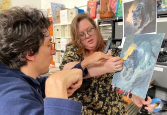 [CREDIT: Rob Borkowski] Federico “Freddy” Rocco works on a painting from a print of a panther with the help of Carrie Hyde, Outsider Collective director. 