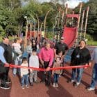 [CREDIT: Rob Borkowski] At left, City Council President Steve McAllister and Mayor Frank Picozzi, center, cut the ribbon on the new Apponaug Playground.