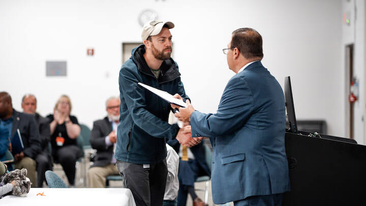 [CREDIT: CNE] U.S. Army Reserve Medical Corps Major Dr. Benjamin Misemer, a Kent Hospital ER doctor, receives a citation from RI House Speaker Joseph Shekarchi at the hospital Oct. 12.