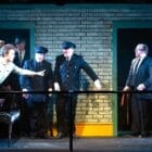 [CREDIT: Cat Laine] A scene from GAMM Theatre's production of HANGMEN. From left, David Ensor (James Hennessey), Jack Clarke (Guard), John Cormier (Guard), Gabriel Graetz (Syd Armfield), Steve Kidd (Harry); In doorway: Steven Liebhauser (Doctor), Bruce Kaye (Governor)