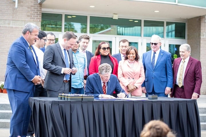 [CREDIT: RI Legislative Press and Information Bureau] Legislative leaders join Gov. Dan McKee for a ceremonial signing of legislation creating the Hope Scholarship Wednesday at Rhode Island College.