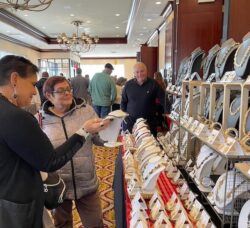 [CREDIT: Rob Borkowski] From left, Robyn Golden, owner of R. Golden Designs jewelry, and designer of said jewelry, reviews a piece with Maureen Lilla. Golden's husband, Jeffrey, looks on.