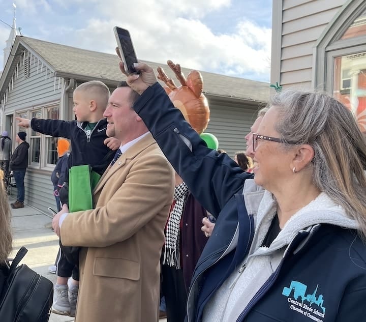 [CREDIT: Rob Borkowski] Shaun Galligan - Vice Chairman, School Committee, his son, Chase, and Lauren Slocum, Central RI Chamber Director watch the Rolling, Strolling Apponaug Winter Festival parade Dec. 9.