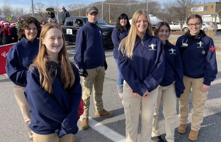 [CREDIT: Rob Borkowski] At the start of the Apponaug Winter Festival parade Dec. 9, members of the Pilgrim High School Lifesaver EMT CMT program: Haylee Marcotte, Destinee Frias, Carolyn Gayman, Alyssa Trudell, Ian Machado, Julie Maloy, RN, and Lisa Tamburini.