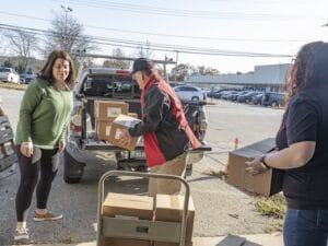 [CREDIT: RI Foundation] Amenity Aid Executive Director Liz Duggan helps load personal hygiene supplies for distribution to households in need. The Warwick nonprofit is one of three organizations whose work was just honored with Best Practice Awards by the Rhode Island Foundation and Blue Cross & Blue Shield of Rhode Island.