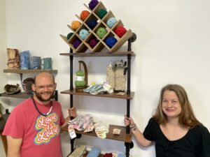 [CREDIT: Rob Borkowski] From left, Knitting artist Robert Brosnahan and Casey Weibust, Gallery manager at Out of the Box Gallery, with some of Brosnahan's wares for sale at the gallery.