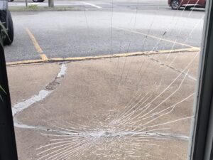 [CREDIT: Jennifer Kane] A view of one of two store doors smashed during a West Shore Road vandalism spree early Saturday, May 18, 2024.