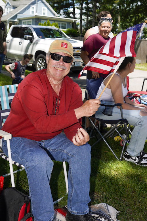 [CREDIT: Laura Paton] Warwick resident John Paul sits outside his home waiting for the 2024 Gaspee Days Parade to pass June 8.