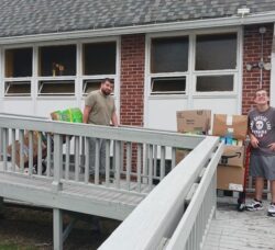 [CREDIT: Lincoln Smith, Photographic Society of RI] From left, Jordan Hiatt and Lucas Franco from WestBay Marketplace bringing cereal from the Lakewood Baptist Cereal Challenge out to load in the van for delivery to WestBay Marketplace.