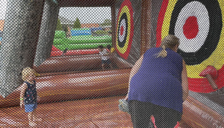 [CREDIT: Rob Borkowski] Cathy Cudoni supervised her grandson, Lincoln, 2, in some inflatable axe-throwing courtesy of Bing's Backyard Bash during Granparent's Day at the Coventry Town Annex Saturday.