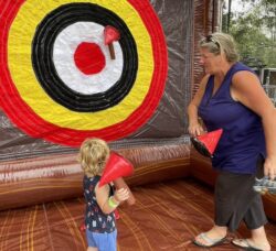 [CREDIT: Rob Borkowski] Cathy Cudoni supervised her grandson, Lincoln, 2, in some inflatable axe-throwing courtesy of Bing's Backyard Bash during Granparent's Day at the Coventry Town Annex Saturday.