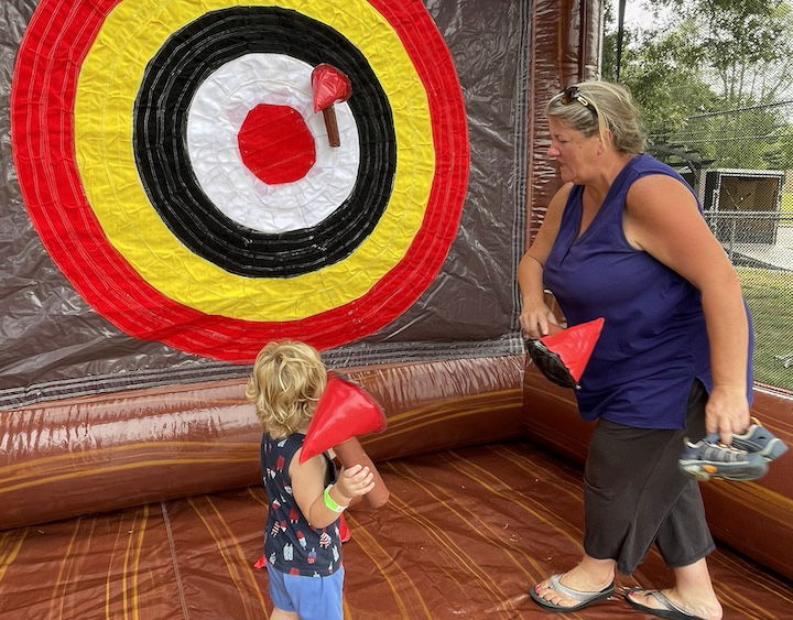 [CREDIT: Rob Borkowski] Cathy Cudoni supervised her grandson, Lincoln, 2, in some inflatable axe-throwing courtesy of Bing's Backyard Bash during Granparent's Day at the Coventry Town Annex Saturday.