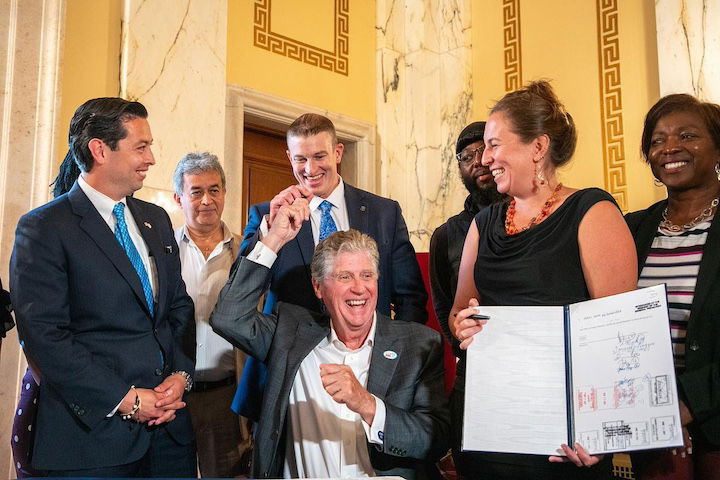 [CREDIT: RI Press & Legislative Info Bureau] Governor McKee hands Representative Evan Shanley a pen used to sign the Secure Choice Retirement Savings Program during an event Thursday, Sept. 5, 2024.