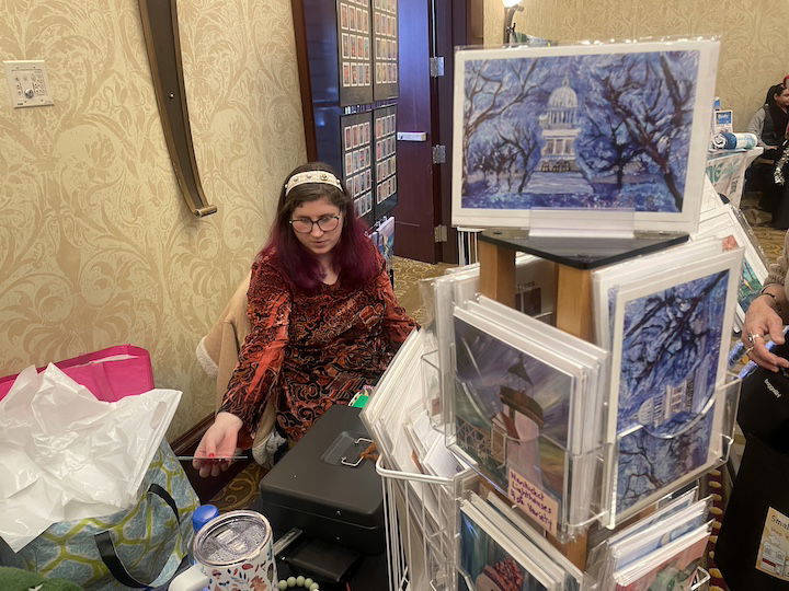 [CREDIT: Rob Borkowski] At Shop RI in Crowne Plaza, Rachel Rasnick, an RIDDC alum, is selling prints of her artwork. One piece, ‘Winter at the State House,” pictured here, was commissioned by Sen. Jack Reed.