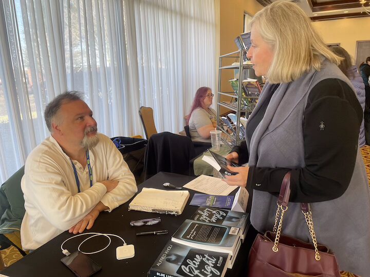  [CREDIT: Rob Borkowski] Al Kholi, author of the scifi thriller, "Blue Light" talks with Lisa Bell, author of, mental health self-help tome, "Get off the Hot Mess Express." during the RI Author Expo Saturday.