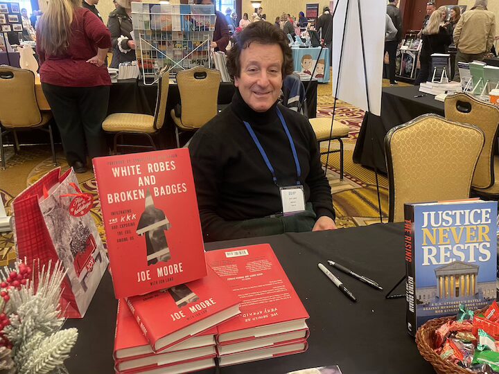 [CREDIT: Rob Borkowski] Local best-selling author Jon Land at the ARIA RI Author Expo Saturday, with his new book, White robes and broken badges : infiltrating the KKK and exposing the evil among us by Joe Moore and Jon Land.