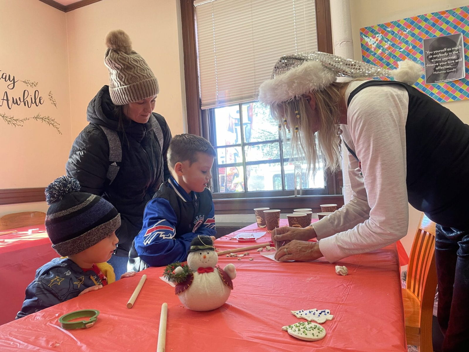 [CREDIT: Rob Borkowski] Warwick Library's Apponaug Branch Manager Diane Iacono, led kids and parents through crafting activities. At left, mom Meghan and sons Elijah, 6 and Gabriel, 3 follow her instructions.