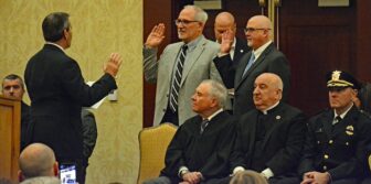  [CREDIT: Rob Borkowski] Mayor Frank Picozzi administers the oath of office to the Warwick School Committee members, from left, re-elected School Committee Member David Testa and newly elected School Committee Member Sean Wiggins, at Crowne Plaza Jan. 7, 2025. 